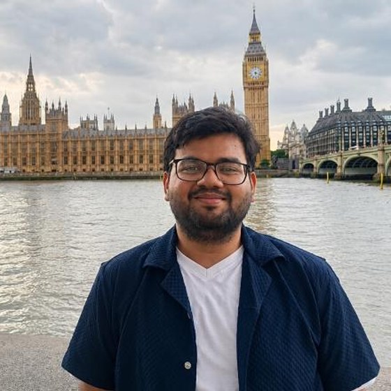 Shivam Dubey standing by the Thames, with the Palace of Westminster behind